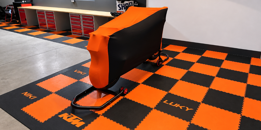 Oranžovočerná podlaha SimpleJack Triton Positron s potiskem KTM ve stylové motodílně